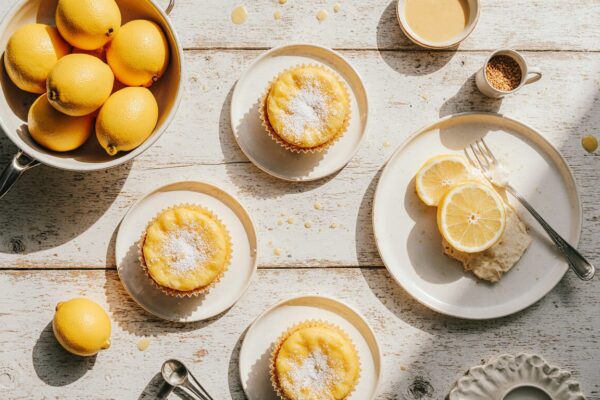 A vibrant assortment of homemade lemon desserts including a glazed loaf, meringue pie, and cookies on a rustic table.