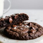 Decadent homemade triple chocolate cookies broken open to show a soft, fudgy center filled with melted chocolate chips, perfectly baked.