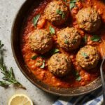 Golden-brown Mediterranean ground beef meatballs simmering in a rich tomato and herb sauce, garnished with fresh parsley