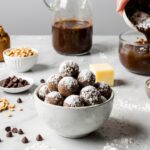A tray of elegant, powdered sugar-dusted Puppy Chow balls, a neat and mess-free version of the classic snack.