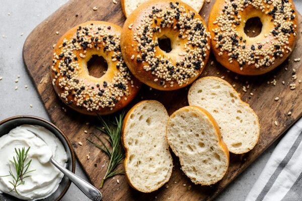 Freshly baked golden brown cottage cheese bagels with everything seasoning, sliced open to show soft interior, served with cream cheese.
