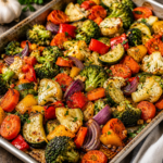 Garlic roasted vegetables with broccoli, cauliflower, carrots, zucchini, bell peppers, tomatoes, and red onion seasoned with herbs and roasted until golden and caramelized.
